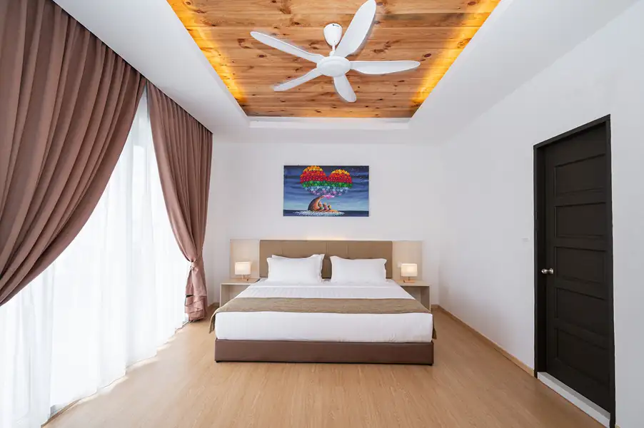 Bedroom with large bed under a traditional wood ceiling with hardwood floors at Sand Bay Resort