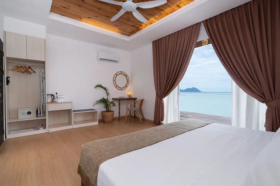 Bedroom with large bed facing the private balcony via glass doors at Sand Bay Resort