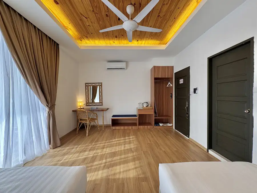 Spacious bedroom with twin beds, open wardrobe and writing desk at Sand Bay Resort