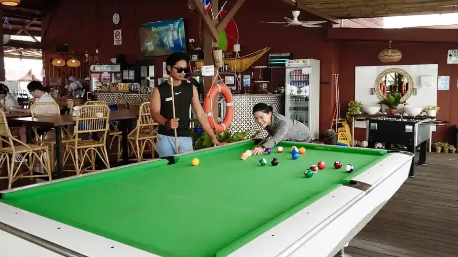 Guests playing snooker in the resort leisure area Sand Bay Resort