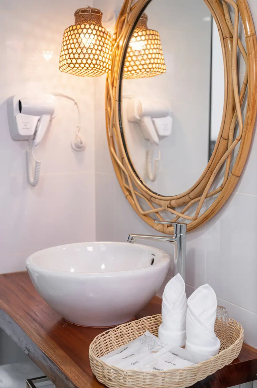 Bathroom with glass shower door, dark textured wall tiles and electric shower at Sand Bay Resort