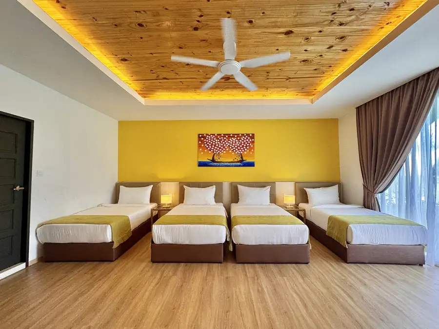 Spacious family bedroom with four single beds facing glass doors at Sand Bay Resort