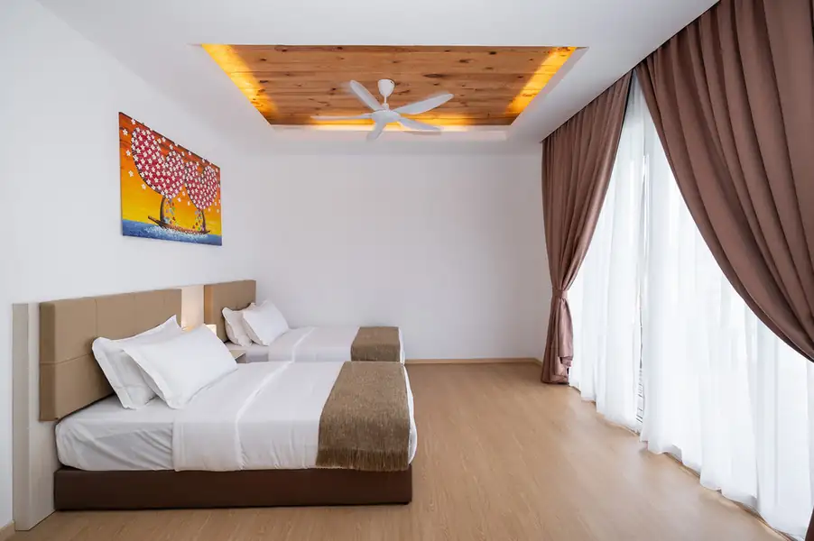 Twin bedroom with two single beds next to glass doors at Sand Bay Resort